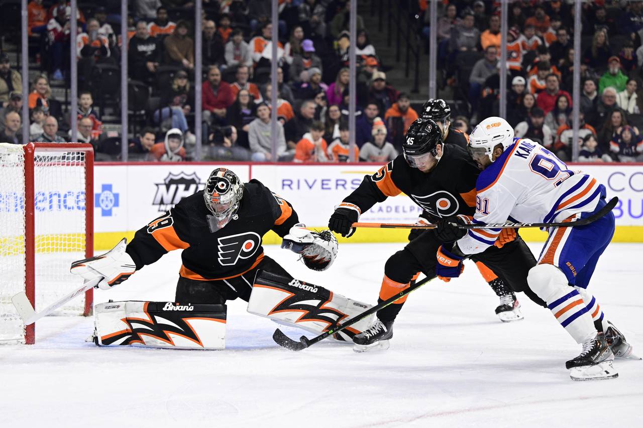 Philadelphia Flyers goaltender Carter Hart, left, makes a save as Cam York (45) and Edmonton Oilers...