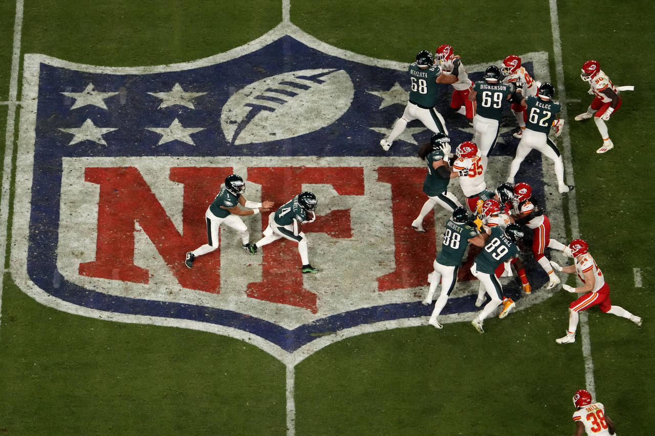 Philadelphia Eagles quarterback Jalen Hurts, left, hands off to running back Kenneth Gainwell (14) ...