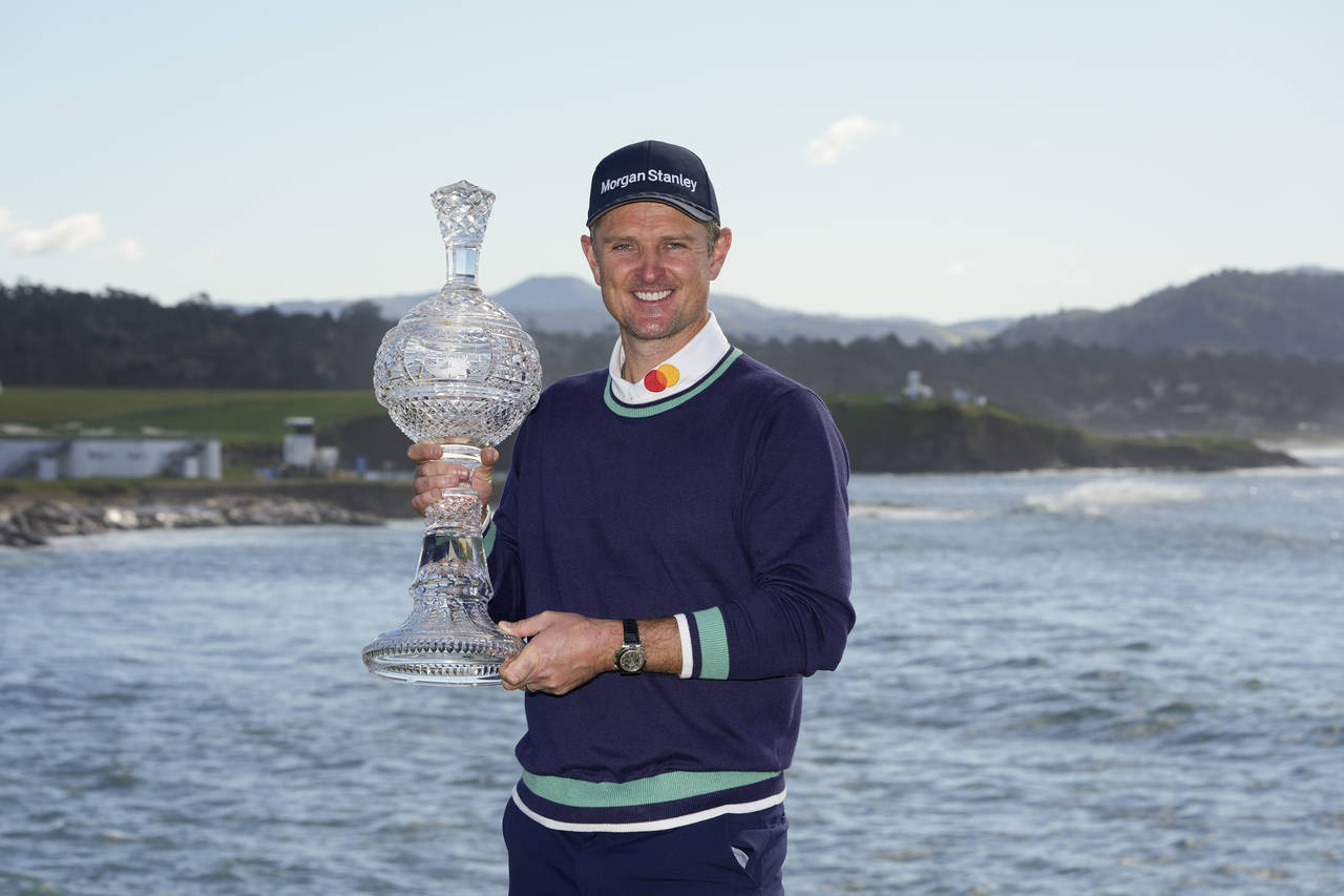 Justin Rose, of England, poses for a photograph with the trophy after winning the AT&T Pebble Beach...