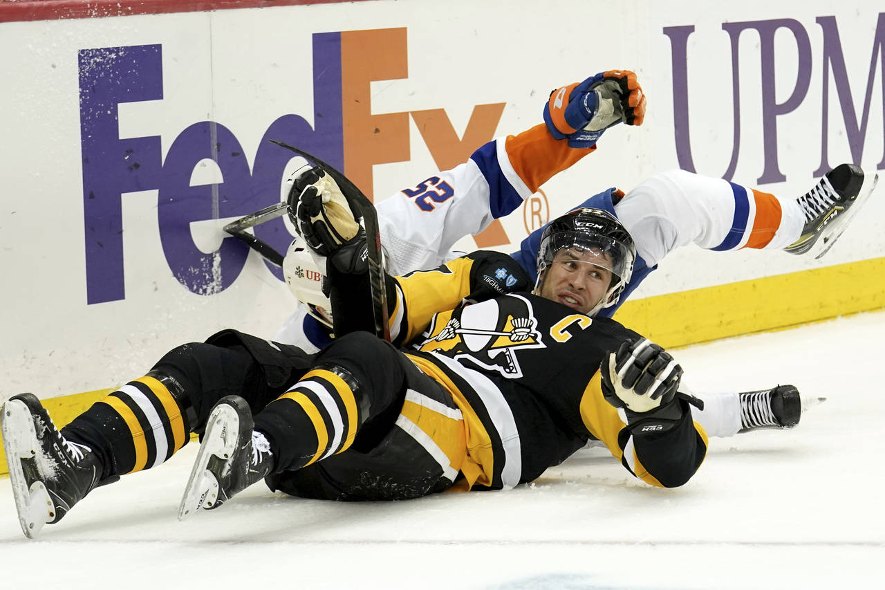 Pittsburgh Penguins center Sidney Crosby (87) collides with New York Islanders defenseman Sebastian...