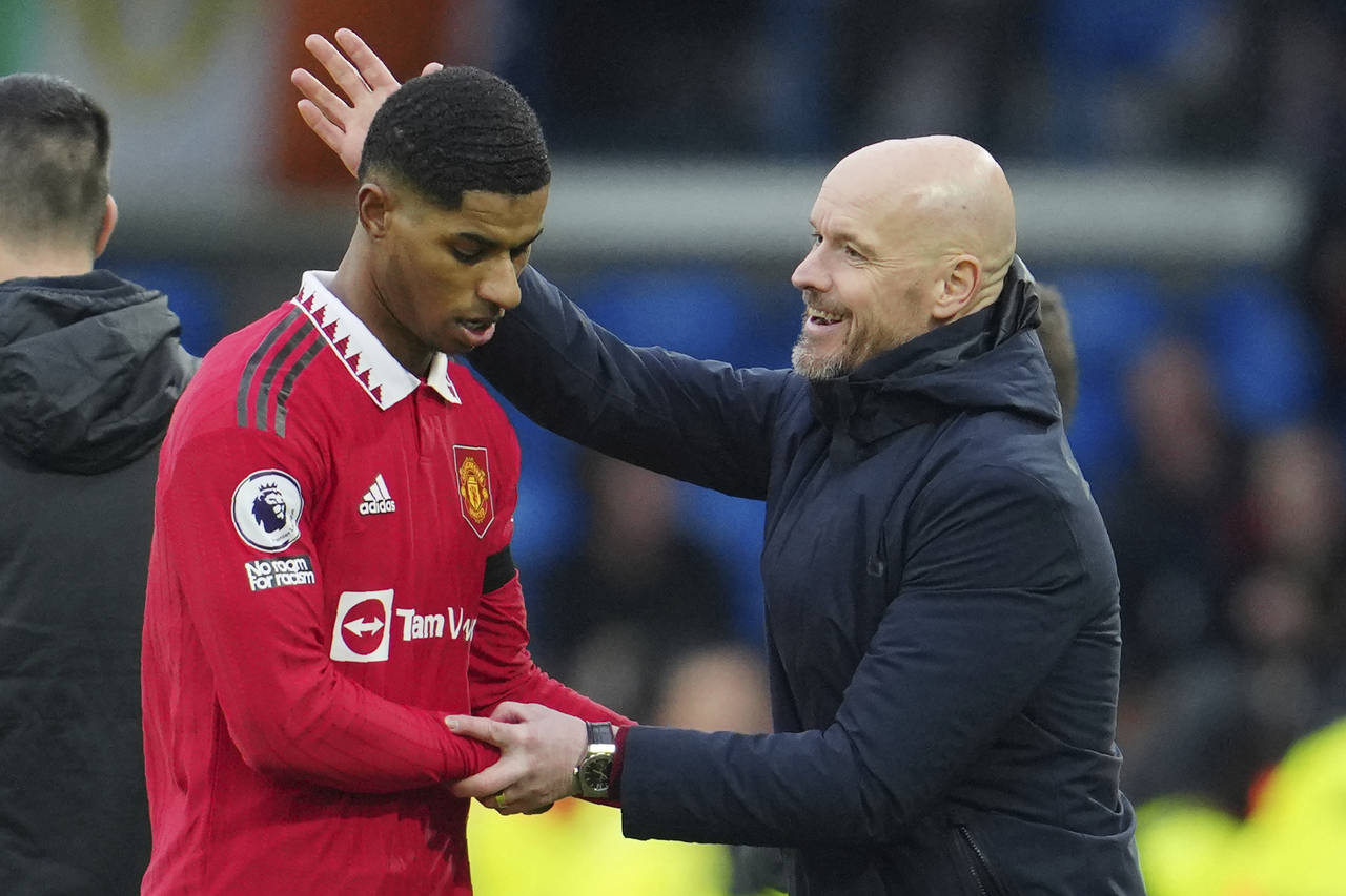 Manchester United's head coach Erik ten Hag congratulates with Marcus Rashford as he leaves the pit...