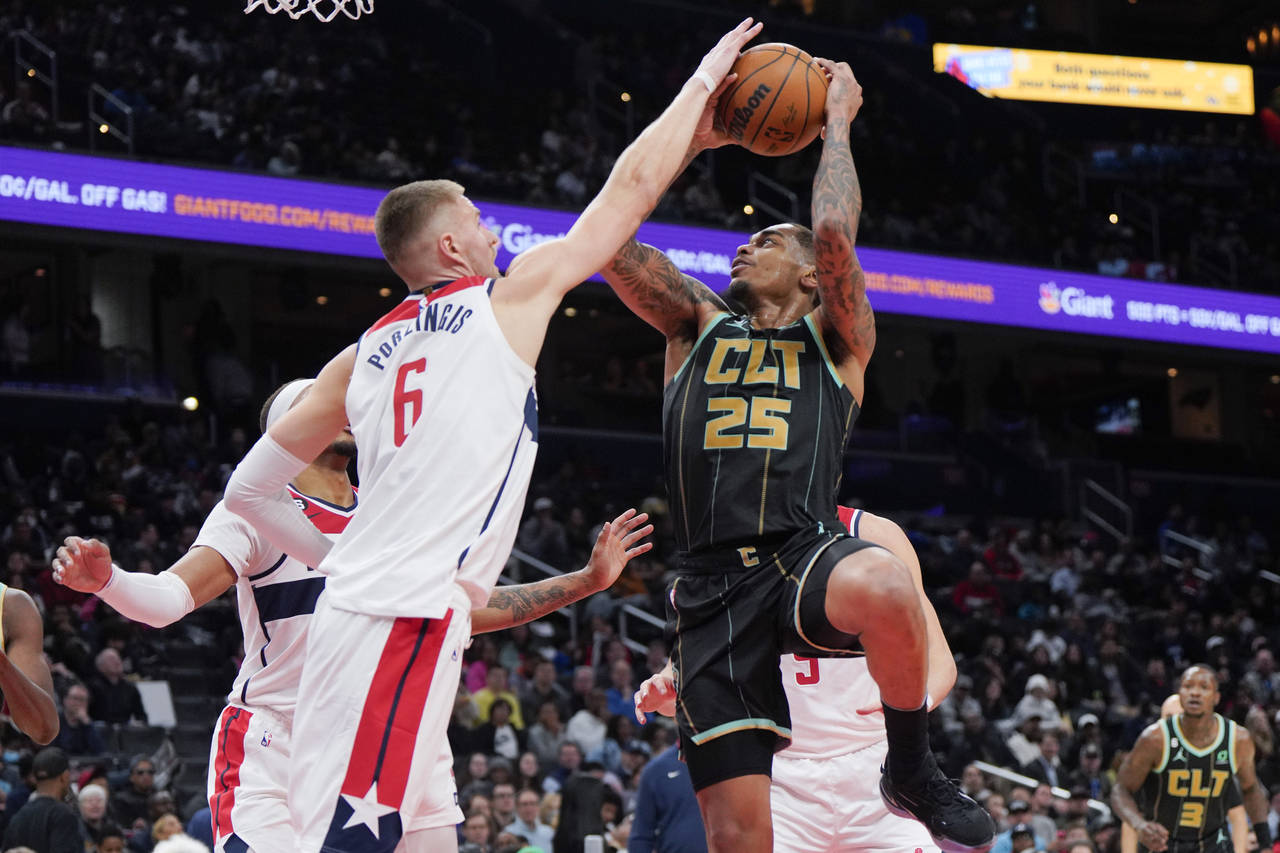 Washington Wizards center Kristaps Porzingis (6) defends as Charlotte Hornets forward P.J. Washingt...
