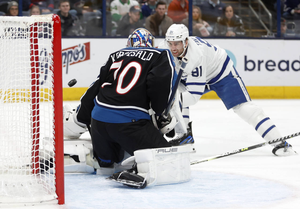 Toronto Maple Leafs forward John Tavares, right, scores against Columbus Blue Jackets goalie Joonas...