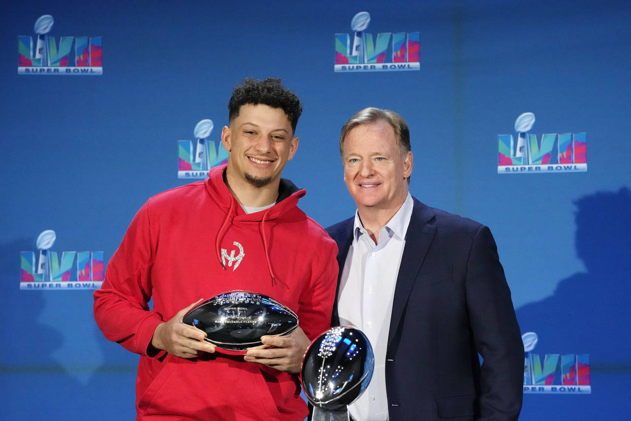Kansas City Chiefs quarterback Patrick Mahomes, left, holds up the Super Bowl MVP Trophy as he stan...