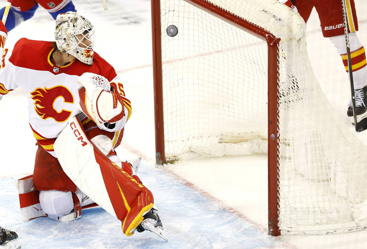 Calgary Flames goaltender Jacob Markstrom (25) looks at the puck shot by New York Rangers center Mi...