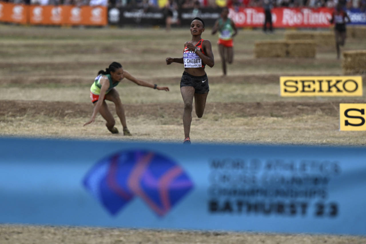 Letesenbet Gidey of Ethiopia, left, falls as Beatrice Chebet of Kenya passes her to win the senior ...
