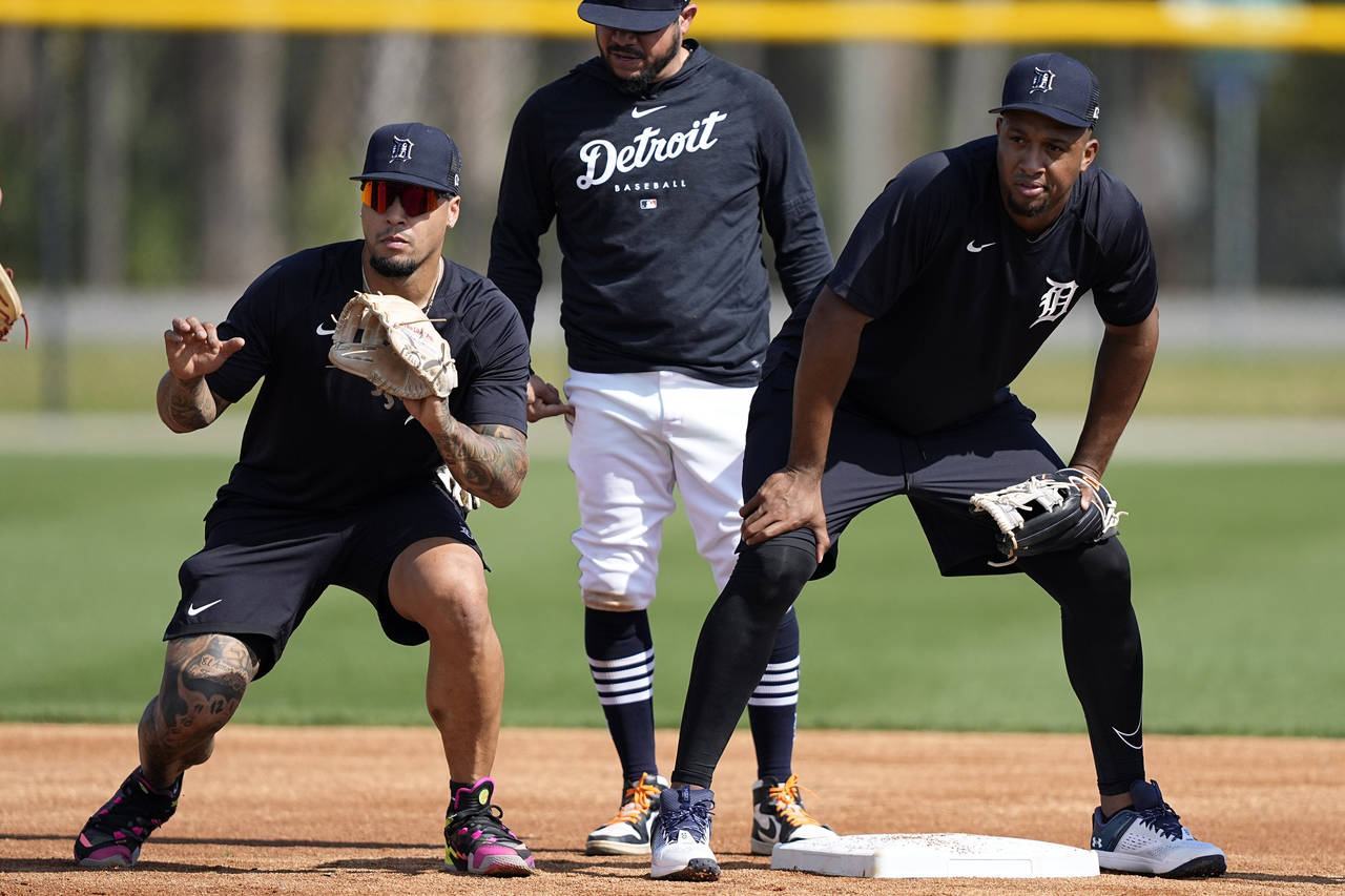 Detroit Tigers infielders Javier Baez, left, and Jonathan Schoop, right, work on drills at second b...