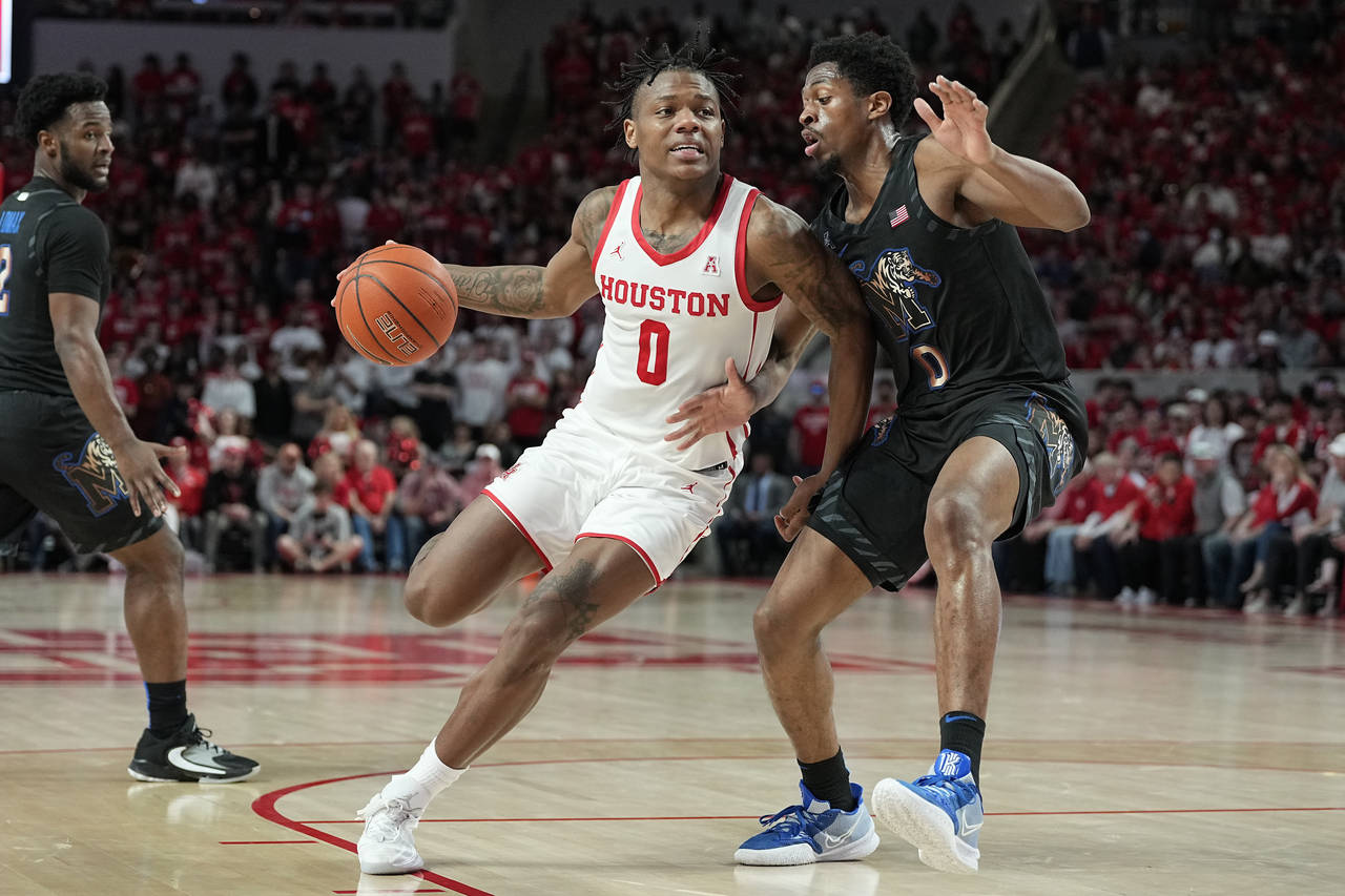 Houston guard Marcus Sasser (0) drives the lane against Memphis guard Elijah McCadden, right, durin...