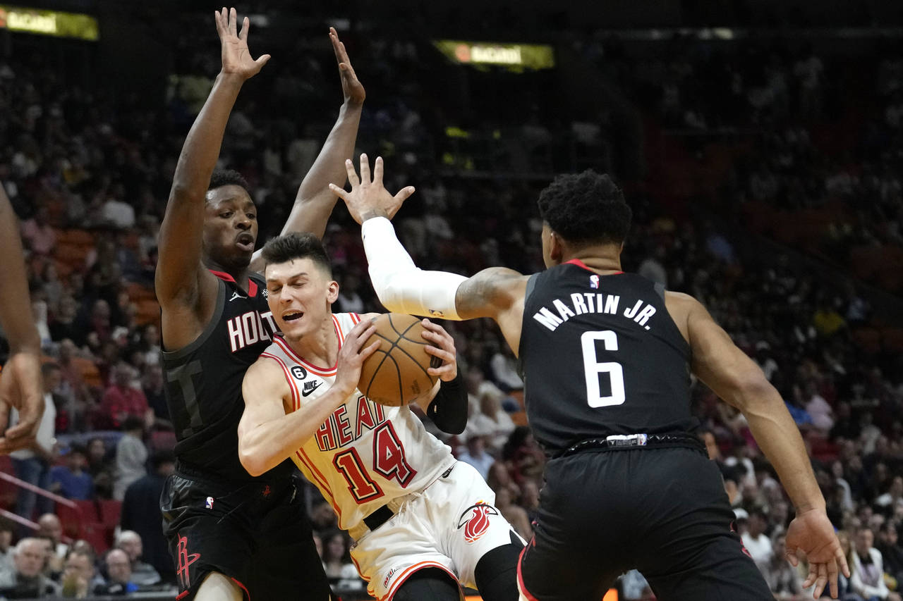 Miami Heat guard Tyler Herro (14) drives to the basket as Houston Rockets forward Jae'Sean Tate, le...