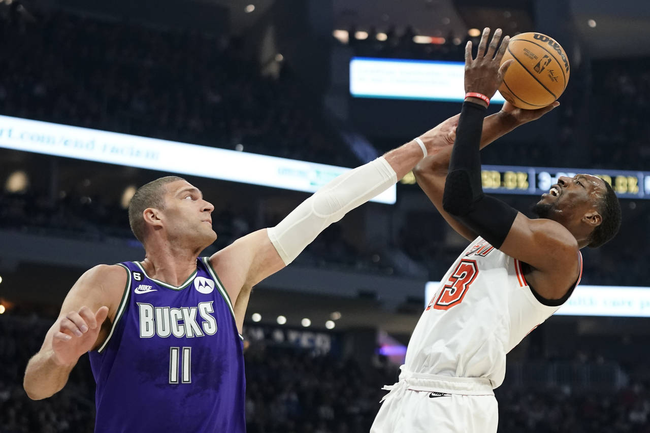 Miami Heat's Bam Adebayo, right, attempts a shot against Milwaukee Bucks' Brook Lopez during the fi...