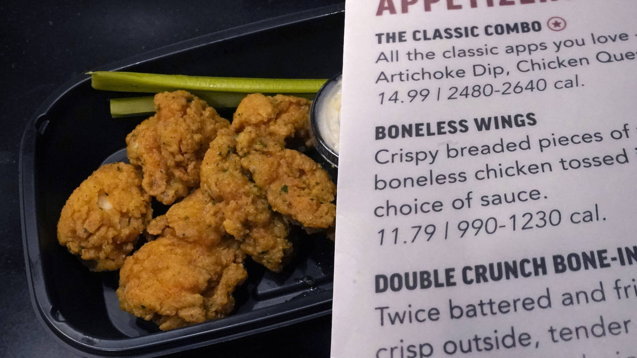 An order of "boneless wings" rests on a counter, along with the menu description, Tuesday, Feb. 7, ...