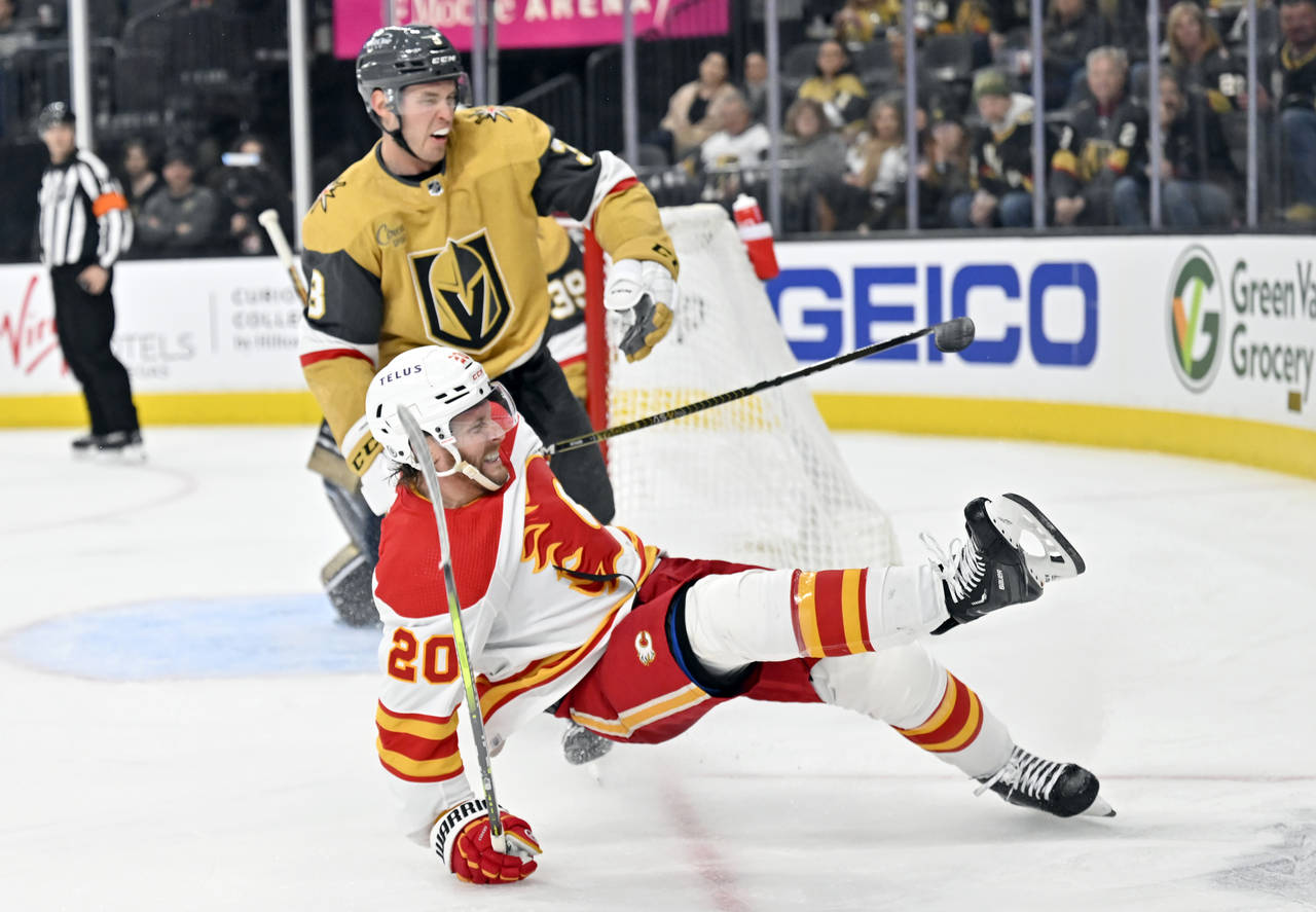 Calgary Flames center Blake Coleman (20) falls to the ice near Vegas Golden Knights defenseman Bray...