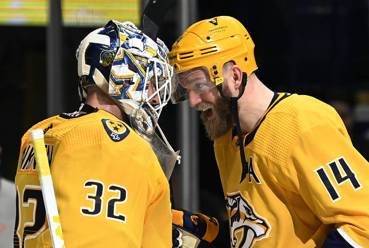 Nashville Predators defenseman Mattias Ekholm (14) celebrates with goaltender Kevin Lankinen (32) a...