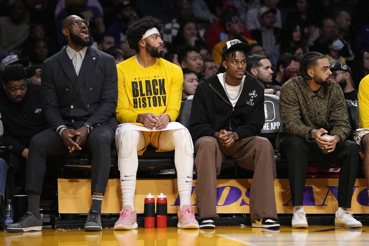 Los Angeles Lakers' LeBron James, left, sits on the bench with forward Anthony Davis, second from l...