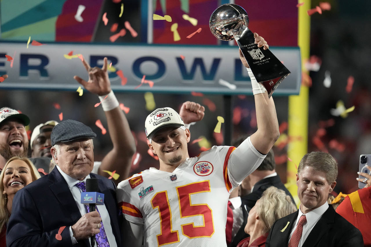 Kansas City Chiefs quarterback Patrick Mahomes (15) holds the Vince Lombardi Trophy next to Terry B...