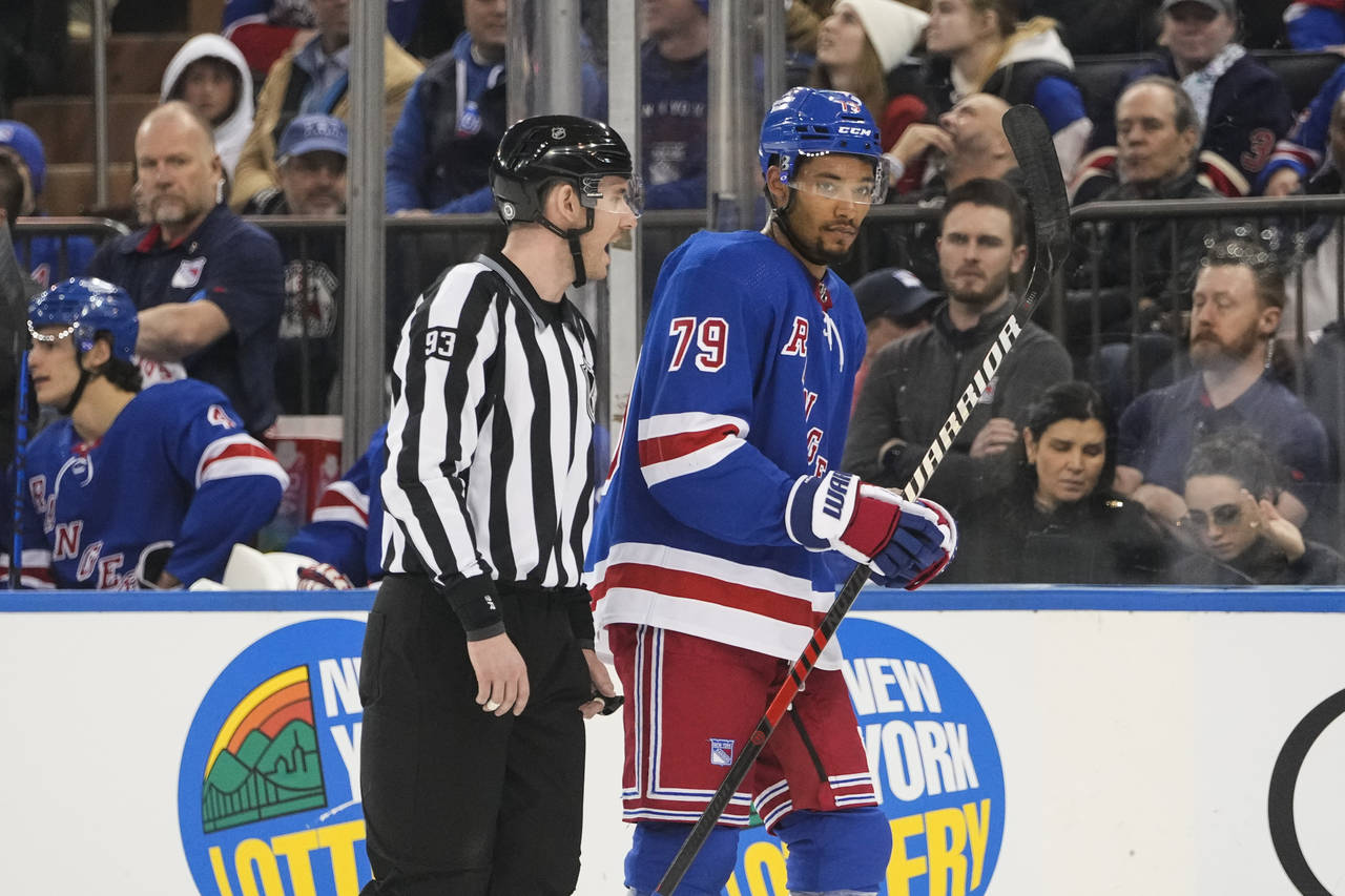 Linesman Kilian McNamara (93) escorts New York Rangers' K'Andre Miller (79) off the ice after Mille...