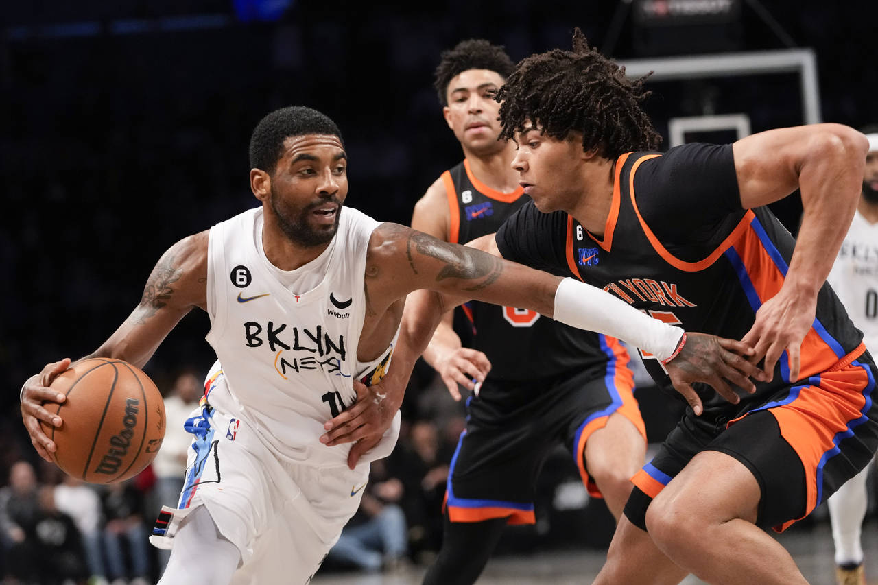 Brooklyn Nets guard Kyrie Irving (11) drives against New York Knicks center Jericho Sims during the...