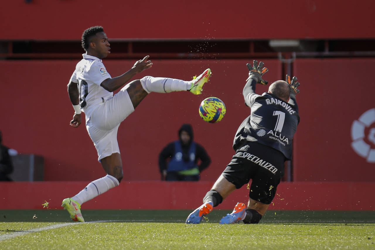 Real Madrid's Vinicius Junior, left, in action against Mallorca's goalkeeper Predrag Rajkovic durin...