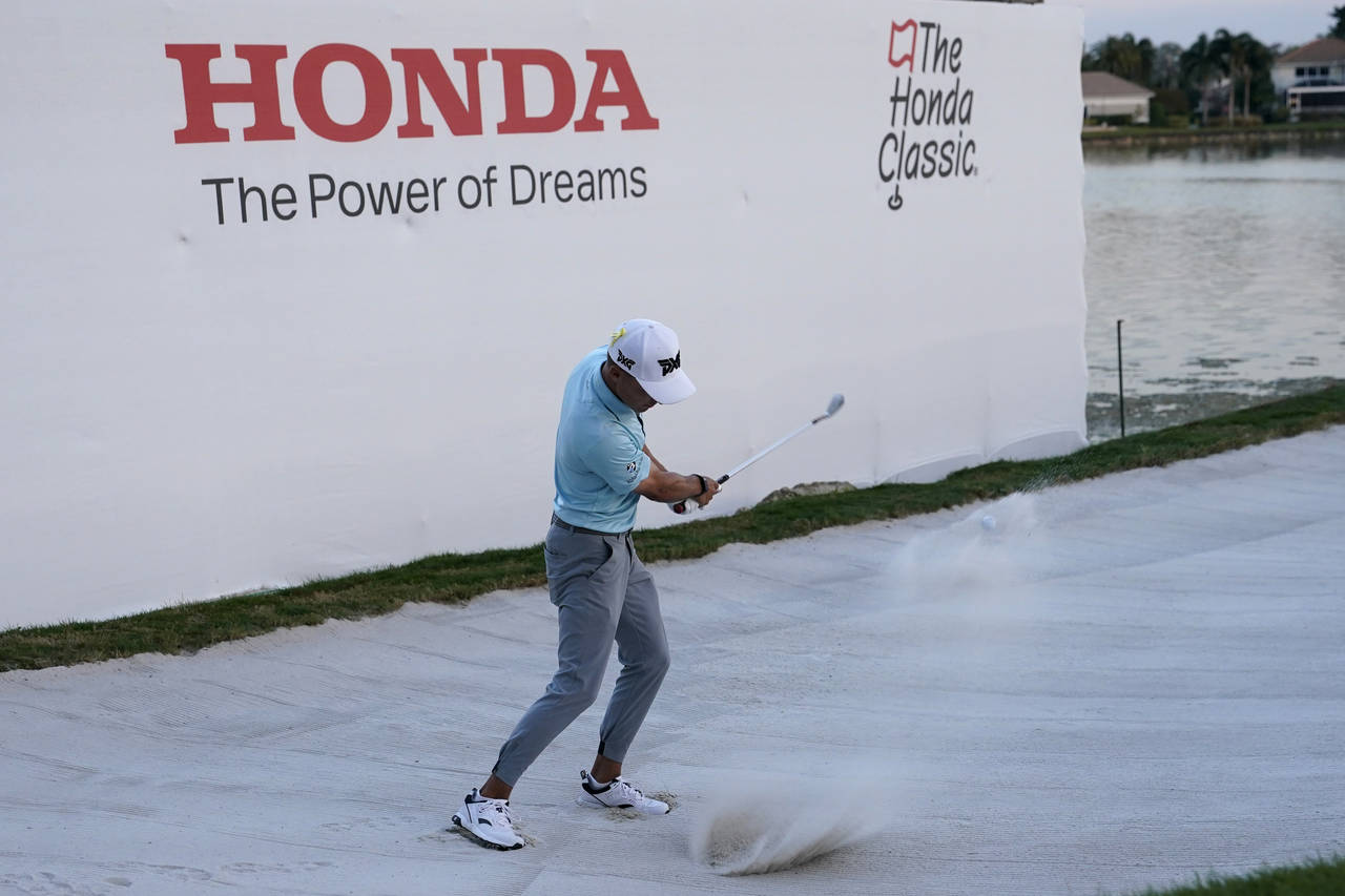 Chris Cole hits from a bunker onto the 18th green during the final round of the Honda Classic golf ...