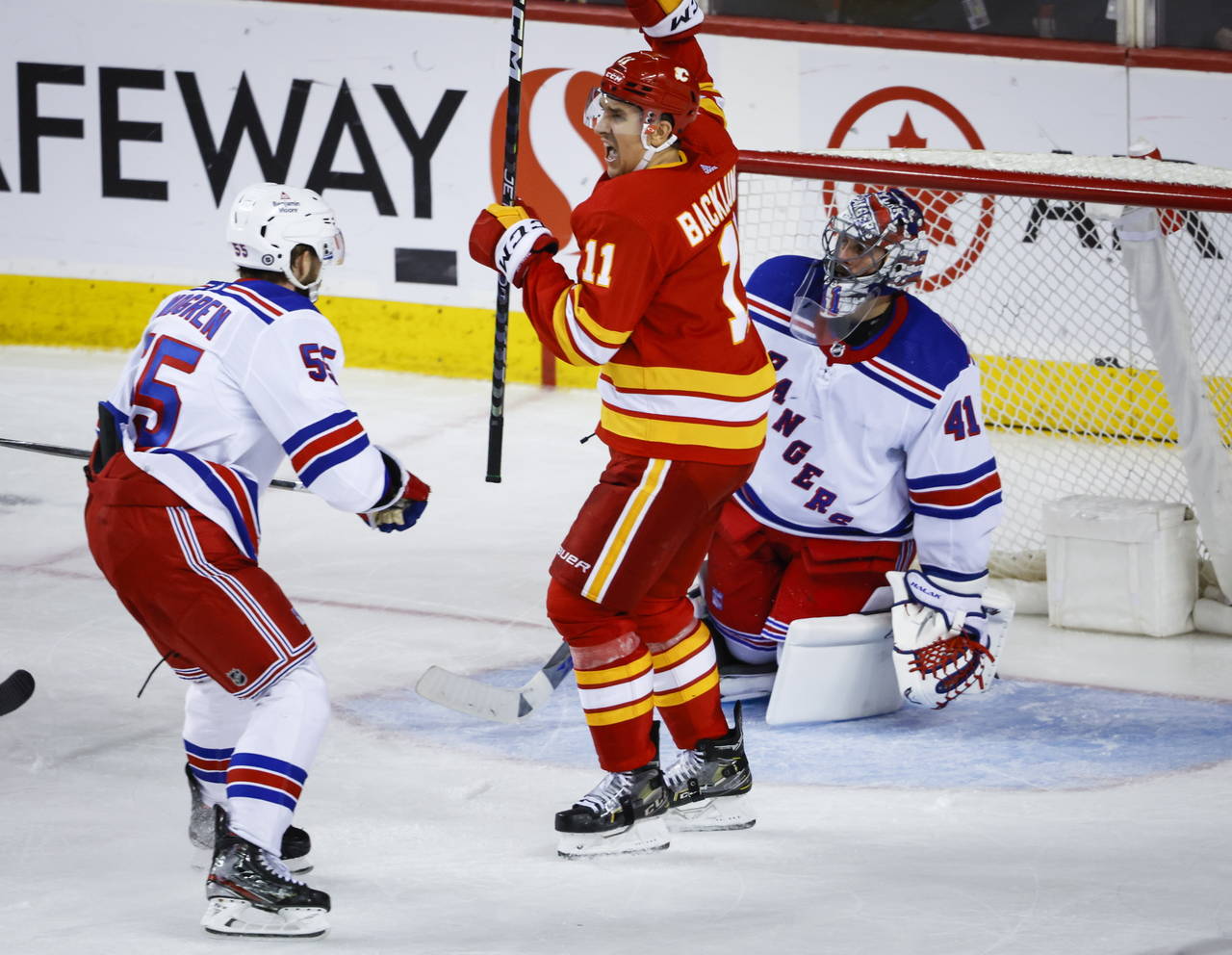 New York Rangers defenseman Ryan Lindgren, left, and goalie Jaroslav Halak, right, react as Calgary...