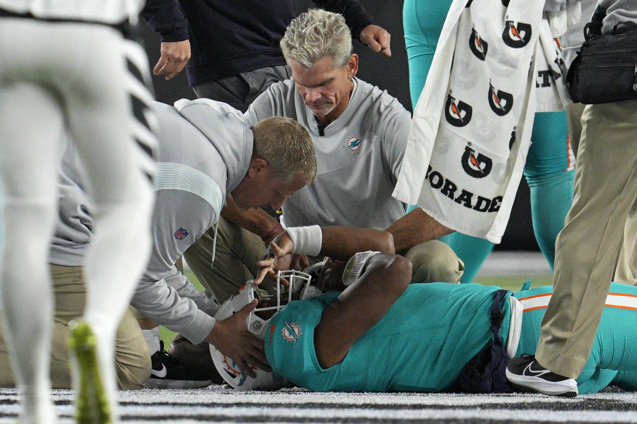 FILE - Miami Dolphins quarterback Tua Tagovailoa is examined during the first half of the team's NF...