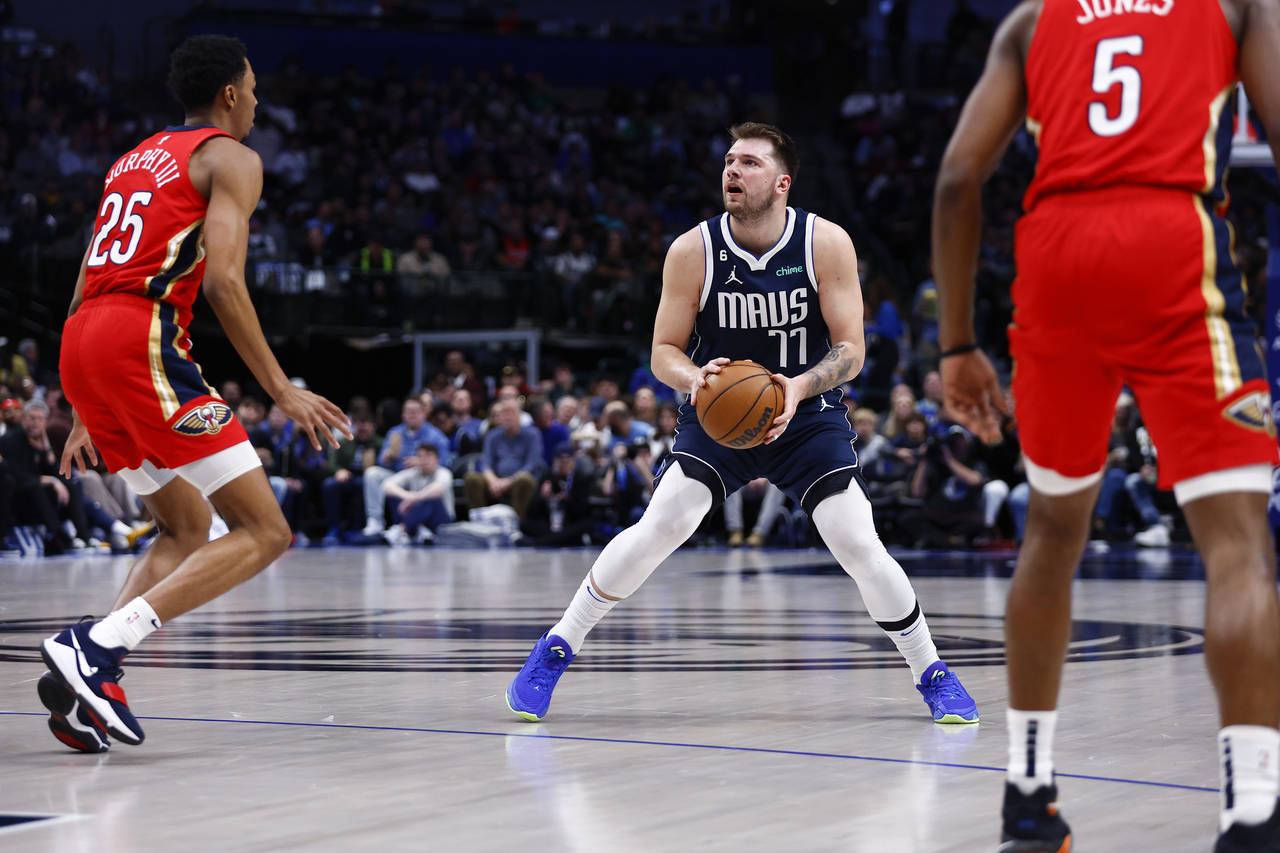 Dallas Mavericks guard Luka Doncic (77) attempts a three-point shot as New Orleans Pelicans guard T...