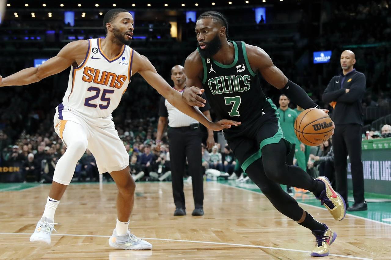 Boston Celtics' Jaylen Brown (7) drives past Phoenix Suns' Mikal Bridges (25) during the first half...