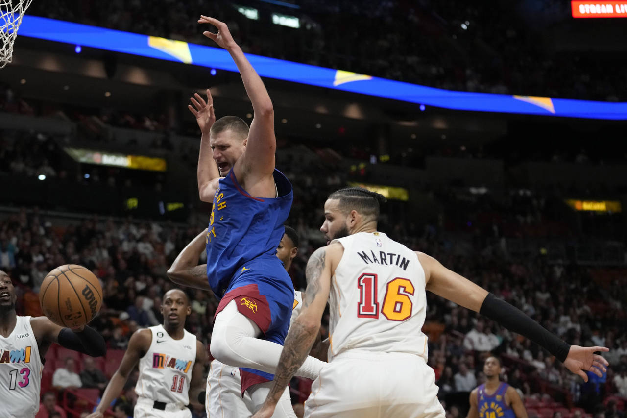 Denver Nuggets center Nikola Jokic, center, loses control of the ball as Miami Heat forward Caleb M...