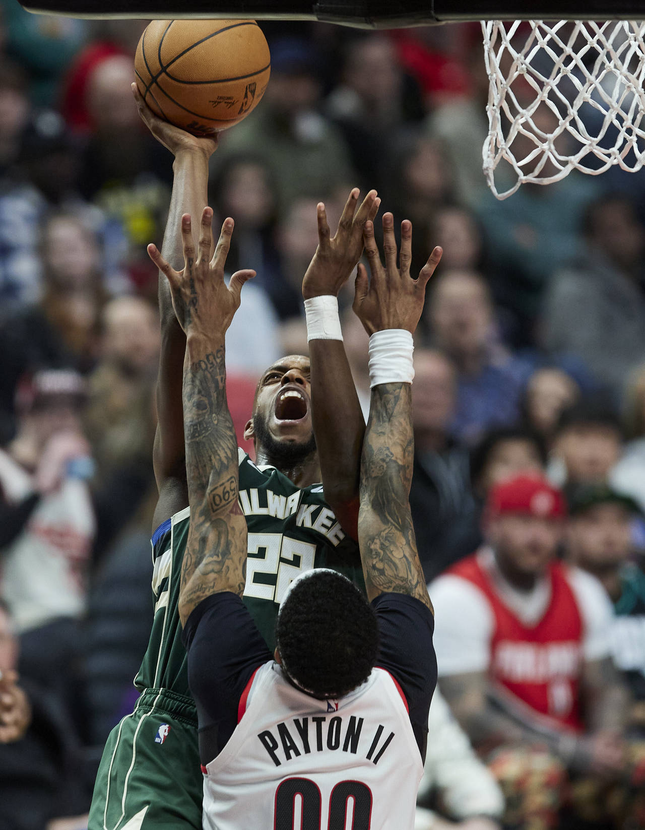 Milwaukee Bucks forward Khris Middleton, top, shoots over Portland Trail Blazers guard Gary Payton ...