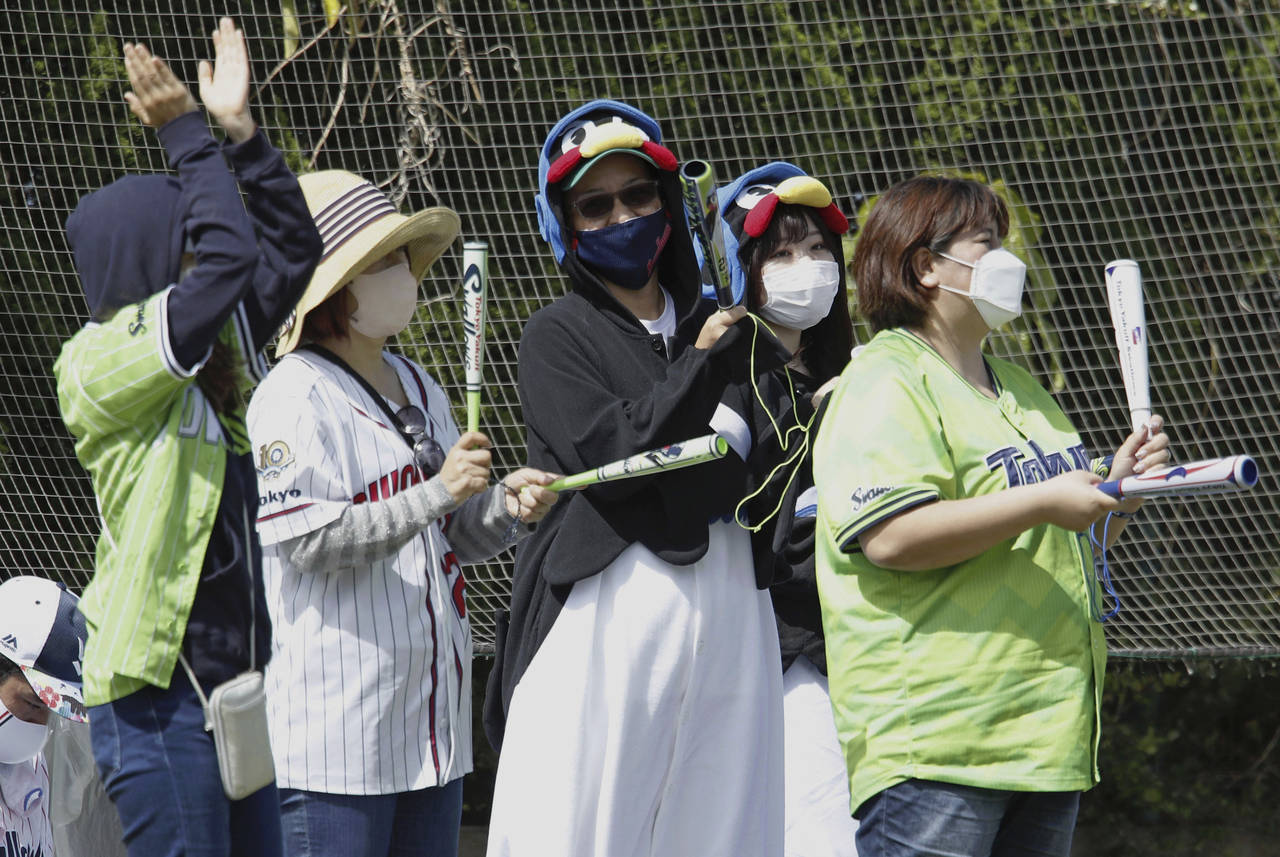 Fans for the Tokyo Yakult Swallows, a Japanese major league baseball team, cheer during the team's ...