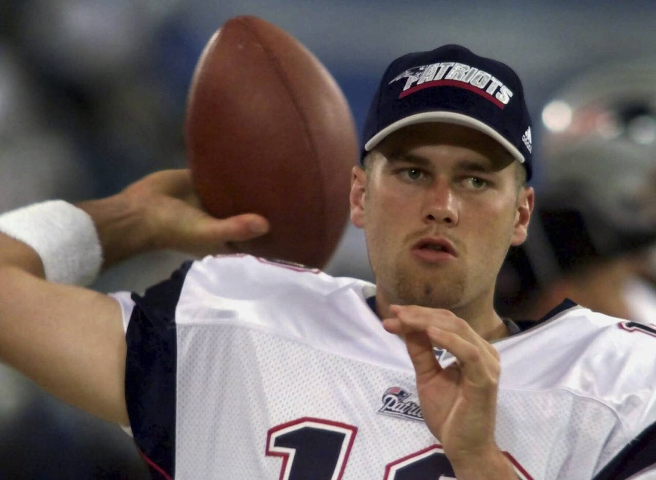 FILE - New England Patriots backup quarterback Tom Brady warms up on the sidelines before the game ...