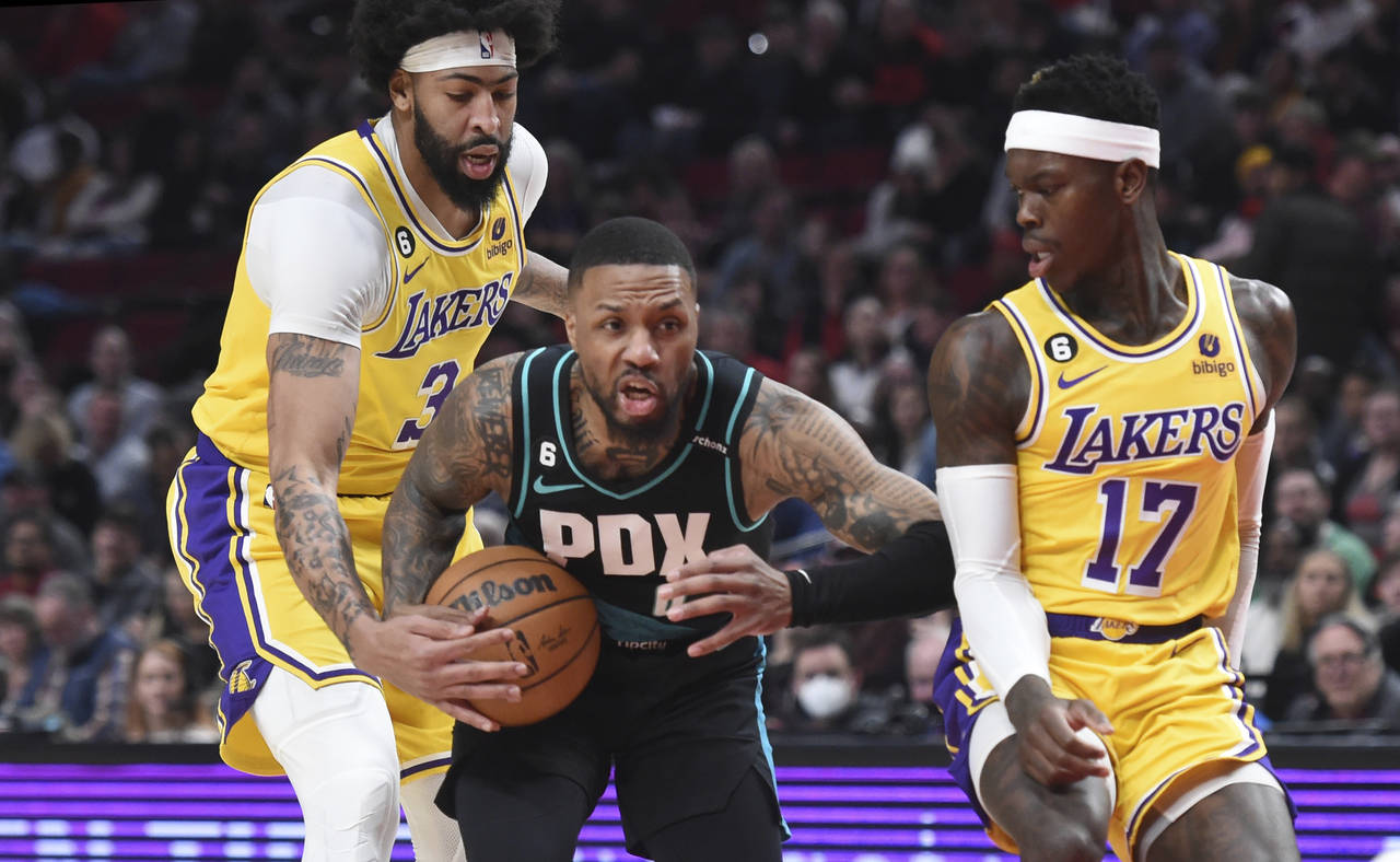 Portland Trail Blazers guard Damian Lillard, center, drives to the basket against Los Angeles Laker...