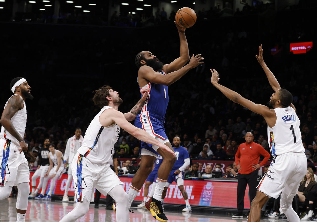 Philadelphia 76ers' James Harden, center, shoots against Brooklyn Nets' Joe Harris, second from lef...