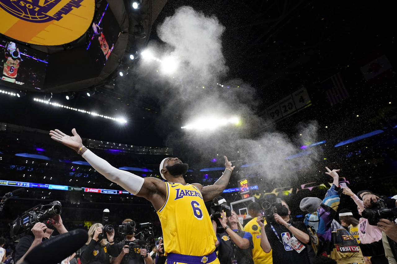 Los Angeles Lakers forward LeBron James tosses powder in the air prior to the team's NBA basketball...