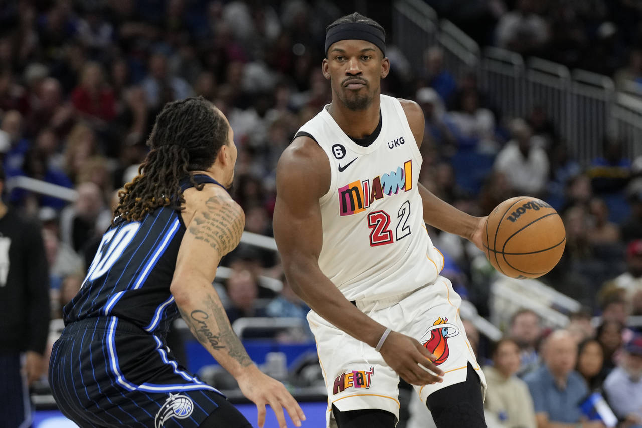 Miami Heat's Jimmy Butler (22) looks for a way around Orlando Magic's Cole Anthony, left, during th...