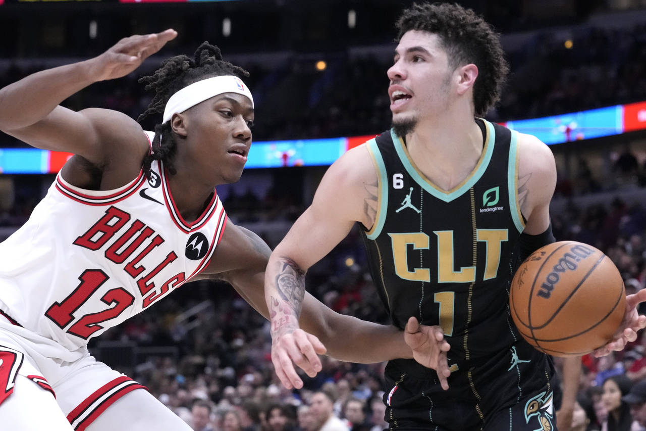 Charlotte Hornets' LaMelo Ball, right, looks to pass as Chicago Bulls' Ayo Dosunmu defends during t...