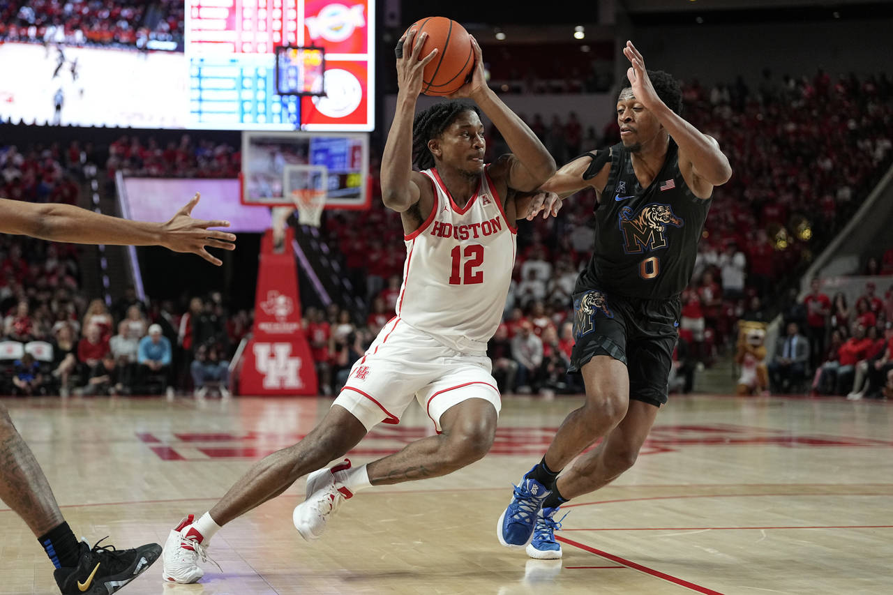 Houston guard Tramon Mark (12) drives around Memphis guard Elijah McCadden (0) during the second ha...