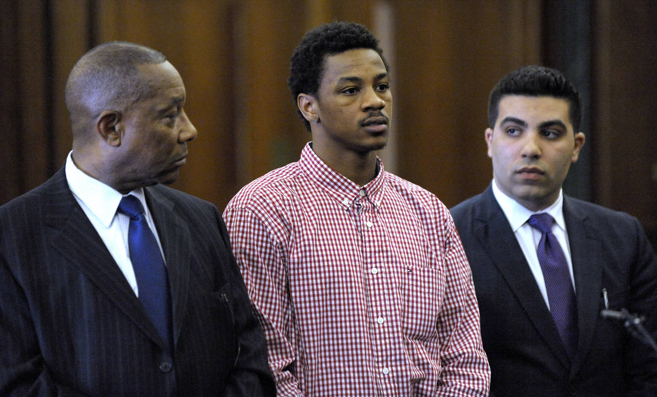 FILE - Former Michigan State basketball player Keith Appling, center, is is flanked by his attorney...