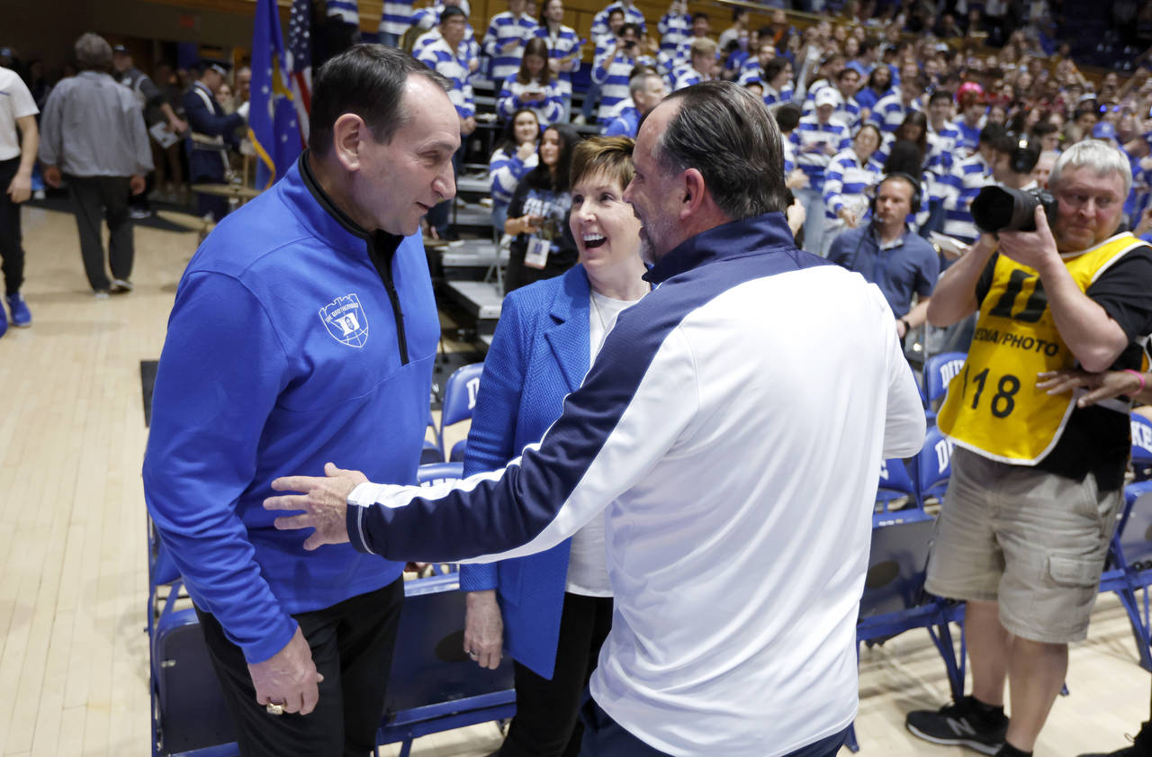 Former Duke head coach Mike Krzyzewski, left, and his wife, Mickie, laugh with Notre Dame head coac...