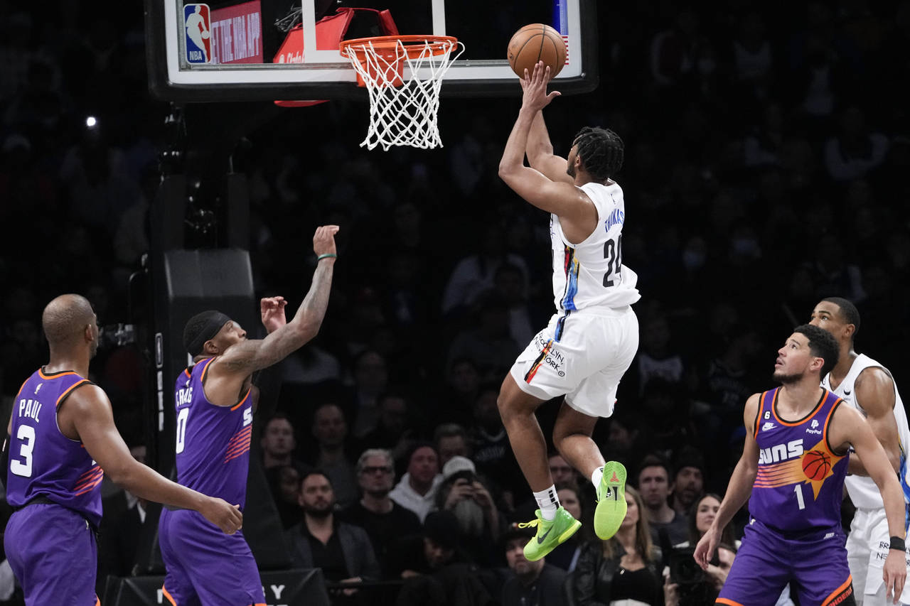 Brooklyn Nets guard Cam Thomas (24) goes to the basket past Phoenix Suns guard Chris Paul (3), forw...