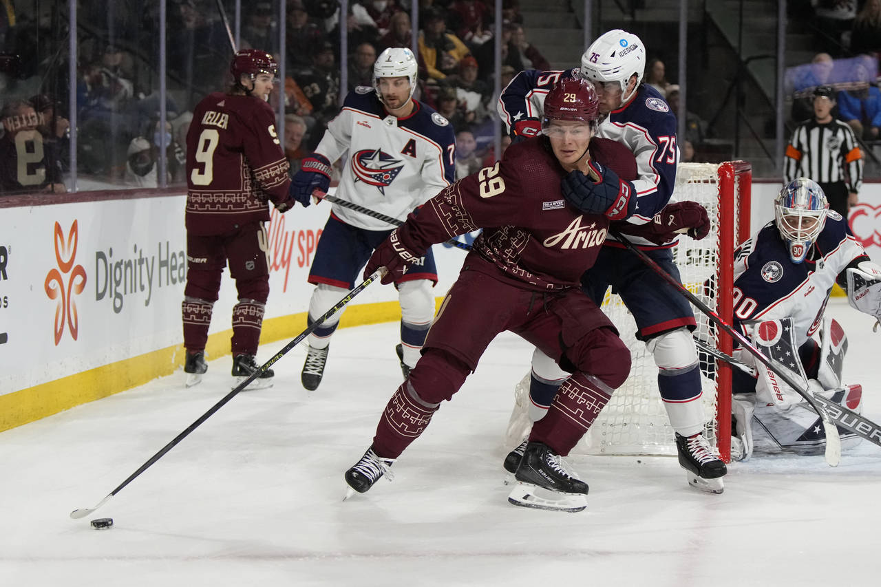 Arizona Coyotes center Barrett Hayton (29) shields Columbus Blue Jackets defenseman Tim Berni (75) ...