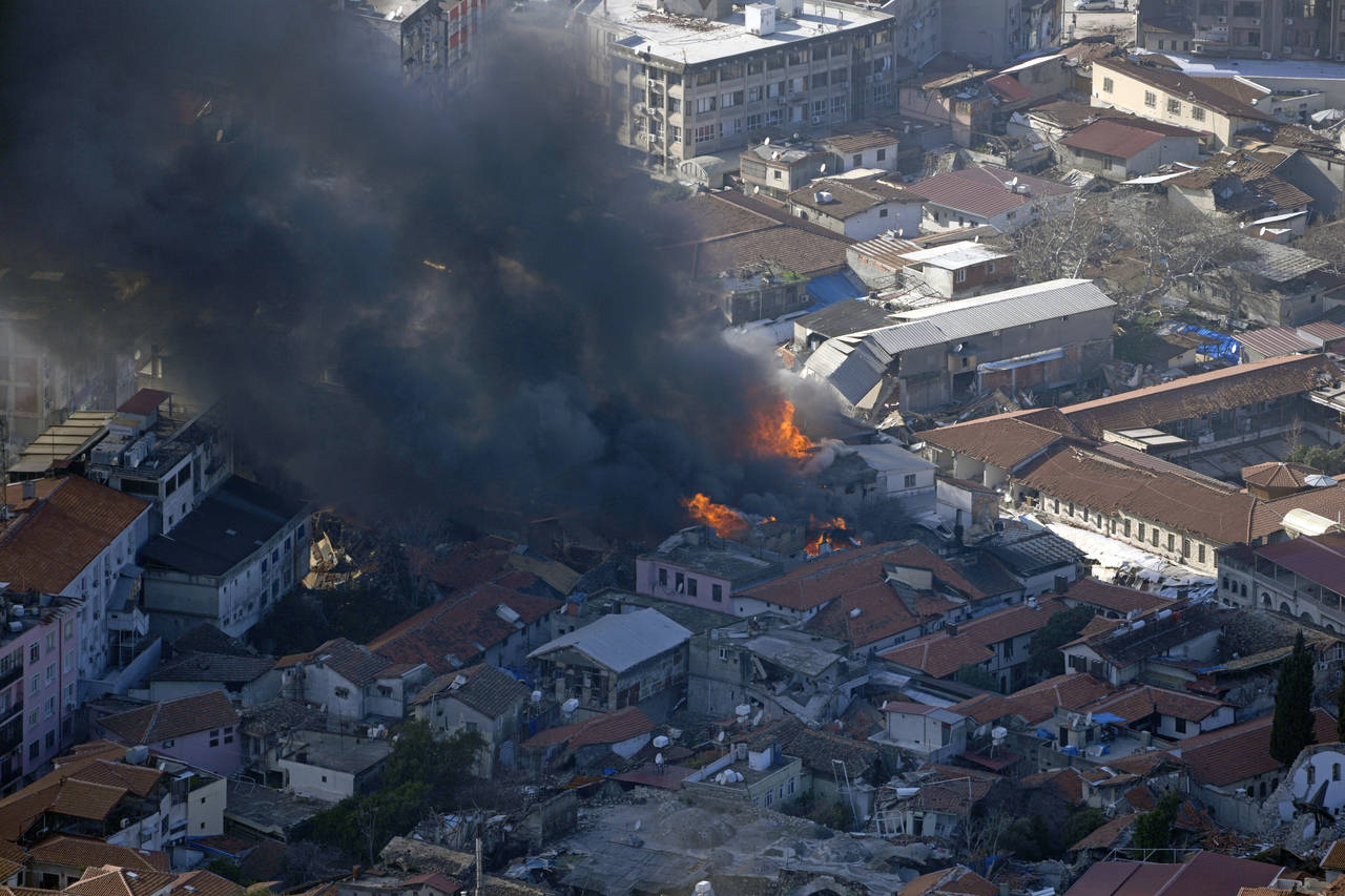 Smoke rises from a building in Antakya, southern Turkey, Wednesday, Feb. 8, 2023. With the hope of ...