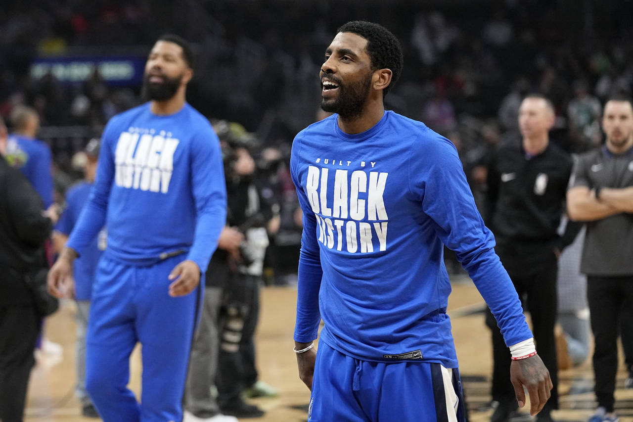 Dallas Mavericks guard Kyrie Irving smiles as he warms up prior to an NBA basketball game against t...