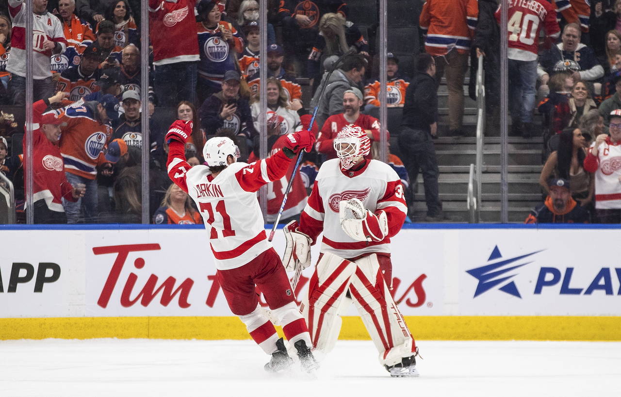 Detroit Red Wings' Dylan Larkin (71) and goalie Ville Husso (35) celebrate the team's win over the ...