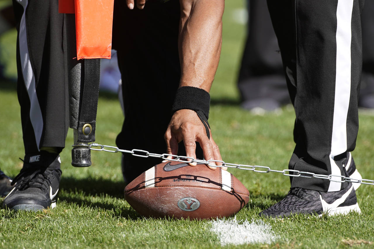 FILE - Officials measure for a first down during an NCAA college football game between USC and BYU,...