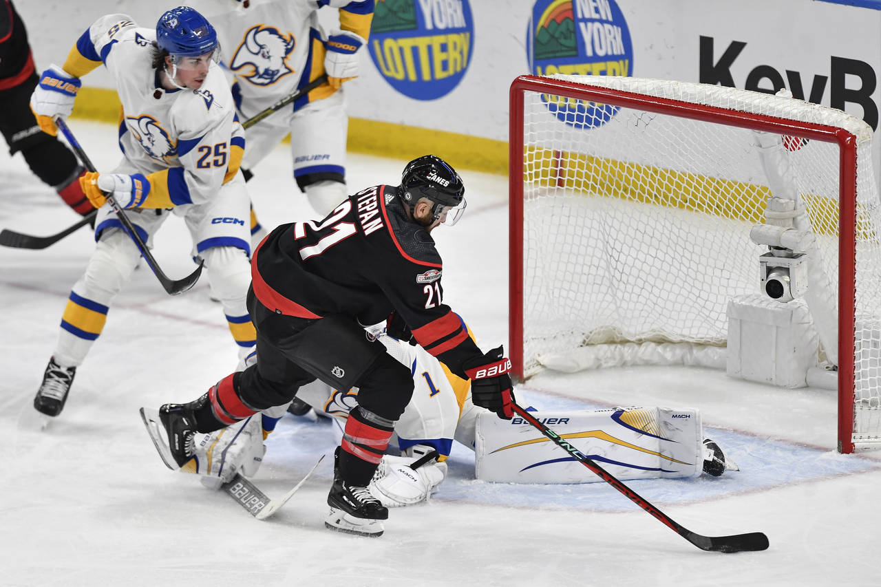 Carolina Hurricanes center Derek Stepan (21) moves the puck around Buffalo Sabres goalie Ukko-Pekka...