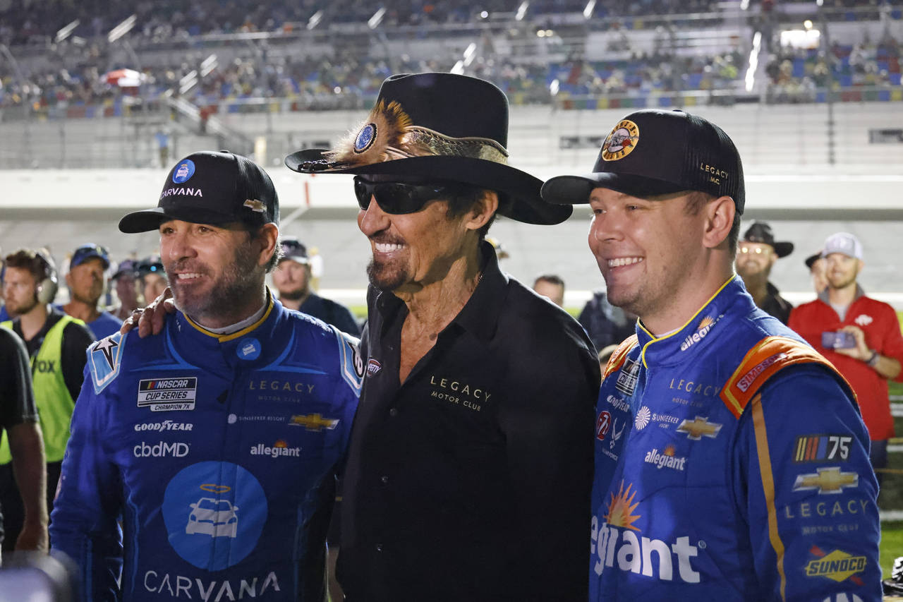 Former NASCAR driver Richard Petty, center, poses for a photo with Jimmie Johnson, left, and Erik J...