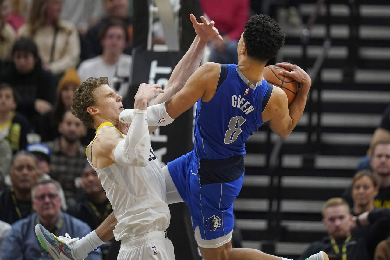 Dallas Mavericks Josh Green (8) goes to the basket as Utah Jazz forward Lauri Markkanen, left, defe...