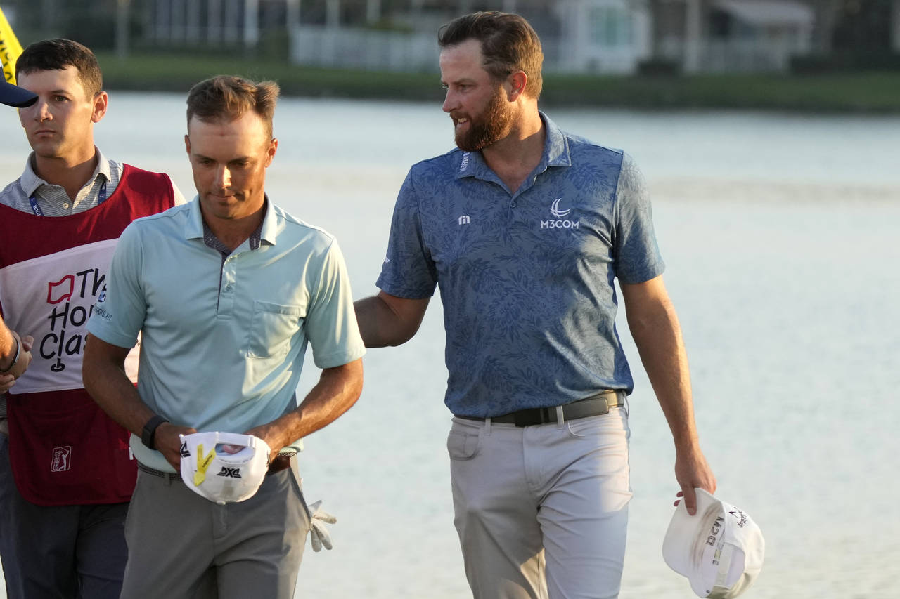 Eric Cole, left, and Chris Kirk, right, walk off the 18th green after regulation play during the fi...