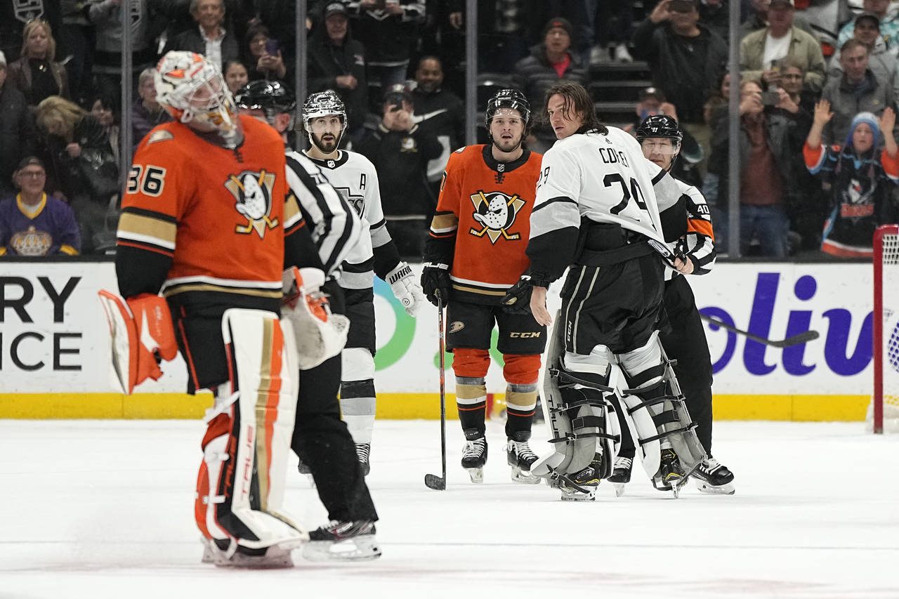 Los Angeles Kings goaltender Pheonix Copley, second from right, is held back by referee Ian Walsh, ...